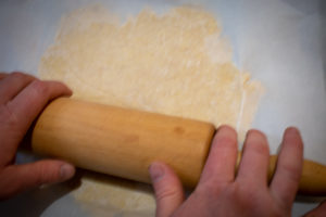 Rolling the Einkorn crust between wax paper